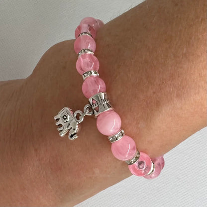Armbånd i rosa glassperler med elefant, vist på modell