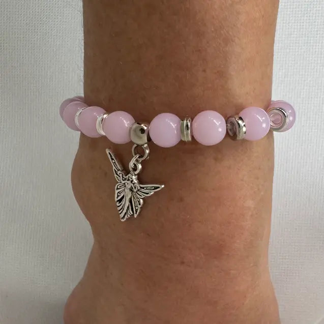 Armbånd i rosa glassperler med anheng, vist på modell