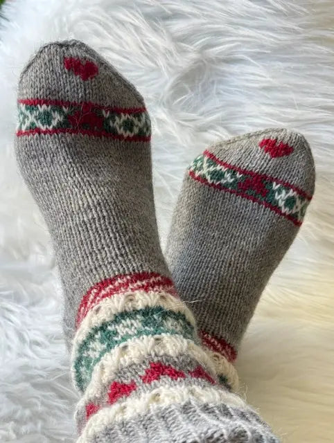HjerteGlimtSokker vist på modell som sitter med beina i kryss