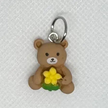 Maskemarkør med brun bamse og gul blomst
