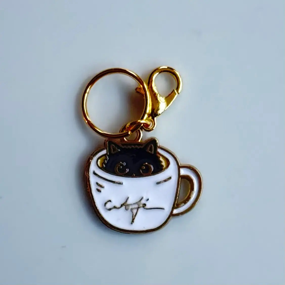 Katt maskemarkør i kaffekopp med gulldetaljer