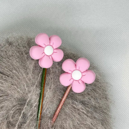 Maskestopper med silikonblomst i lys rosa, på pinnene
