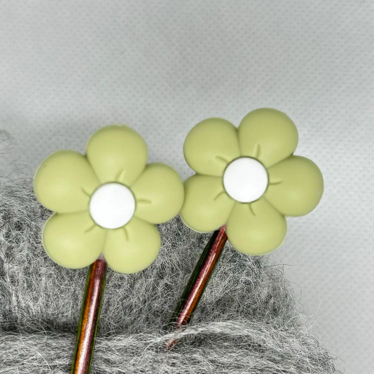 Maskestopper med silikonblomst i mosegrønn, på pinnene