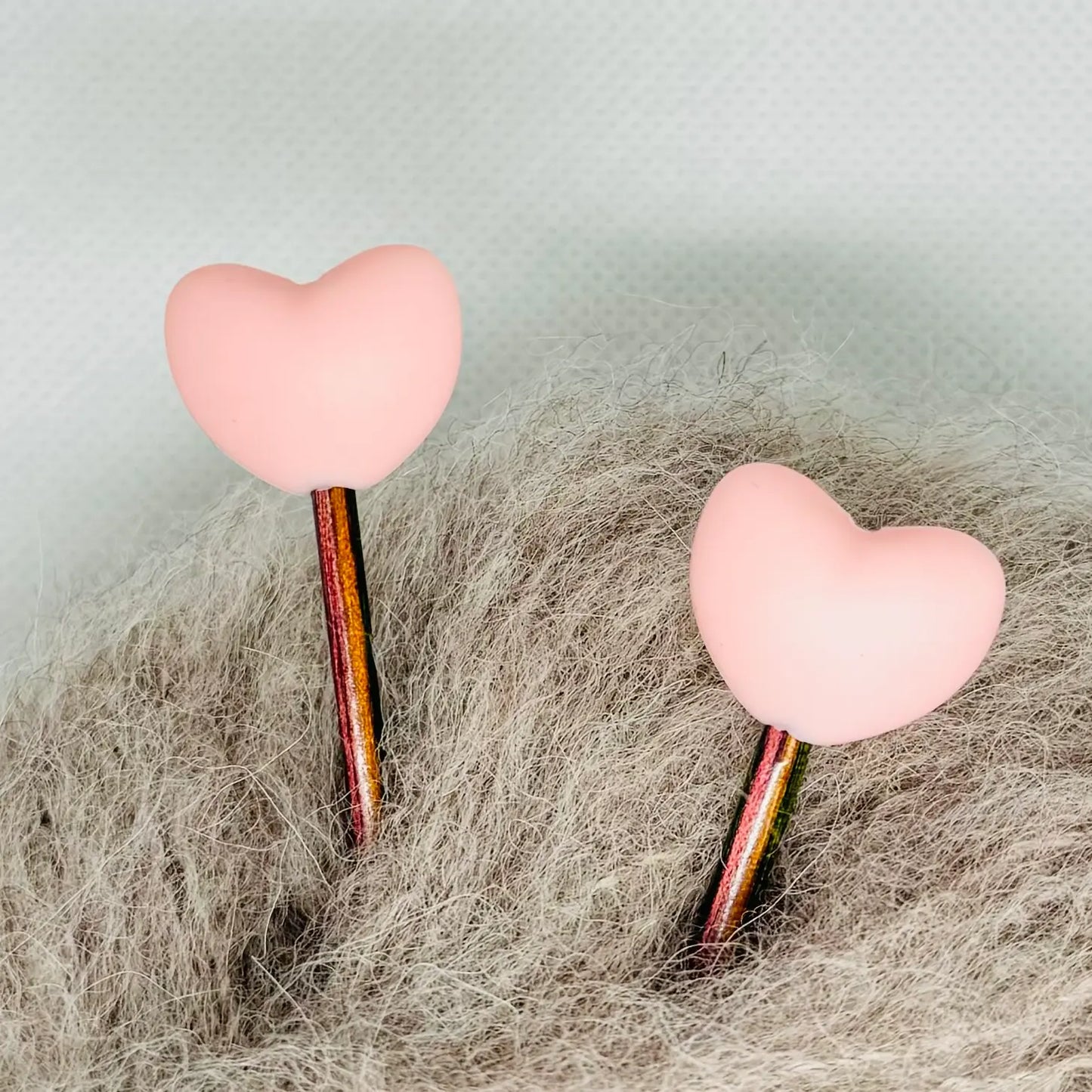 Maskestoppere med rosa silikonhjerter på strikkepinner