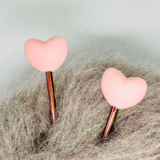 Maskestoppere med rosa silikonhjerter på strikkepinner