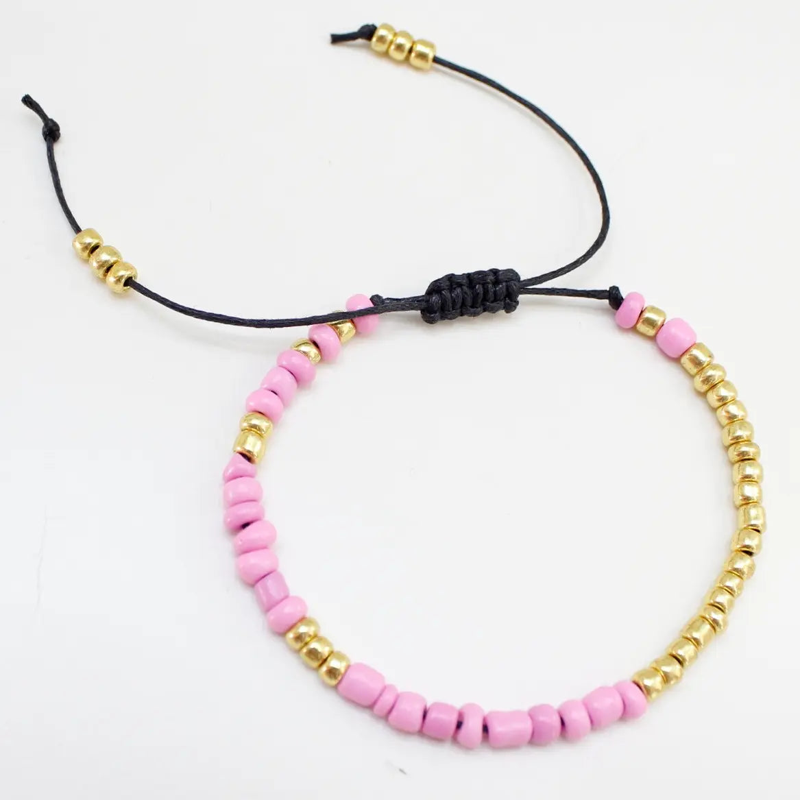 Armbånd på snor i rosa sett liggende