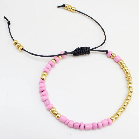 Armbånd på snor i rosa sett liggende