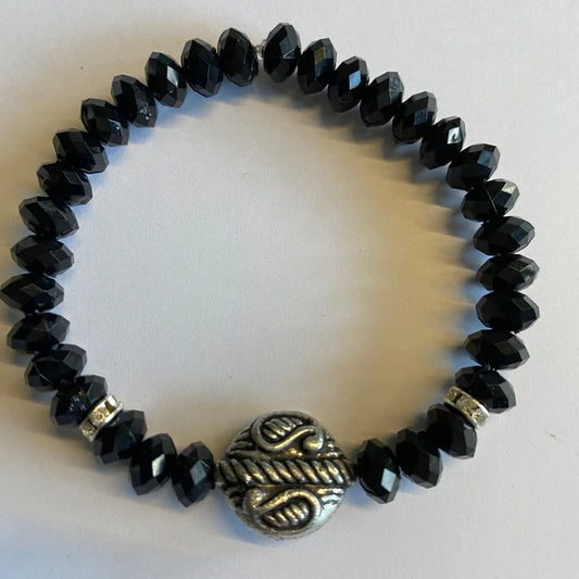 Sort armbånd med grå detaljer vist rett ovenfra