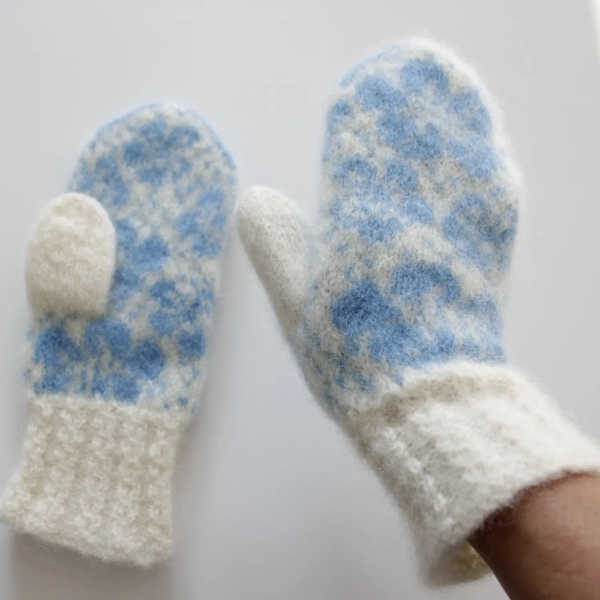 Valmuesøster Tova votter med valmueblomstmotiv og flettemansjett på modell